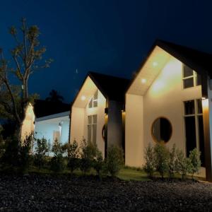 a house lit up at night at ภูไทโฮมสเตย์ บ้านกุดหว้า in Ban Don Um Lua