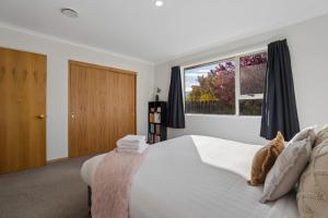 a bedroom with a large bed and a window at Haven on Molyneux in Cromwell