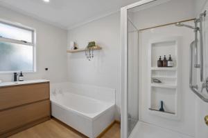a white bathroom with a tub and a shower at Haven on Molyneux in Cromwell +14 photos