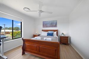a bedroom with a bed and a window at Rundle & Salt in Ulladulla