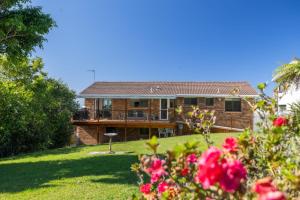 a brick house with a yard with flowers at Rundle & Salt in Ulladulla
