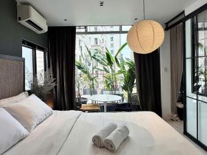 a bedroom with a bed with two towels on it at Jazz Living - Tropical Apartment 5 minutes walk from landmark 81 in Ho Chi Minh City +27 photos