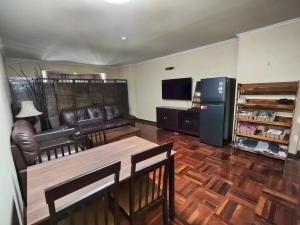 a living room with a leather couch and a television at omni1818 in Bang Kapi