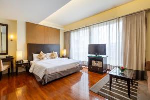 a hotel room with a bed and a television at Kantary House Hotel, Bangkok in Bangkok