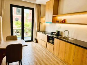 a kitchen with a sink and a table and a window at K-Dragon Hotel Đồi Rồng, Đồ Sơn in Ðông Thôn