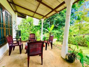 a porch with chairs and a table on a house at Oli Guest House in Diyatalawa