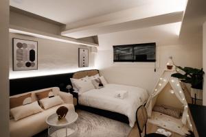 a small bedroom with a bed and a couch at We2 Design Hotel in Taichung