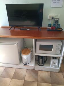 a desk with a microwave and a tv on top at Wimmera Motel in Nhill