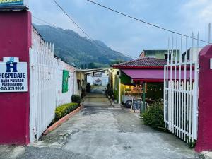 an alley with a white fence and a building at casa demaiz in Choachí