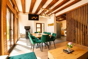 a dining room with a table and green chairs at Lunor House in Izvoare