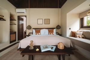 a bedroom with a large white bed and a table at ALMA SHANTI Boutique Hotel in Uluwatu +186 photos