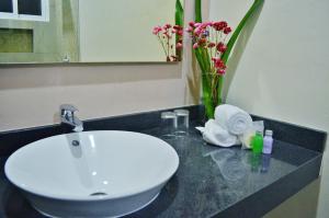 a bathroom with a sink and a vase with flowers at Hacienda Morelos Beachfront Hotel in Puerto Morelos