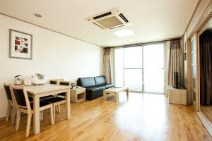 a living room with a table and a couch at Sono Belle Jeju in Jeju +4 photos
