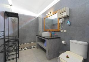 a bathroom with a toilet and a sink and a mirror at KyGunAya Villa in Gili Islands +18 photos