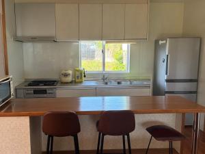 a kitchen with a wooden counter top and a refrigerator at 本部コテージnobaru in Motobu