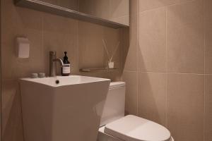 a bathroom with a white sink and a toilet at 서울역 2분거리, 클레어맨션 201 in Samgong +23 photos