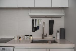 a kitchen counter with a sink and utensils at 서울역 2분거리, 클레어맨션 201 in Samgong
