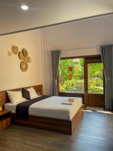 a bedroom with a bed and a large window at May Farm in Hương Hóa +63 photos