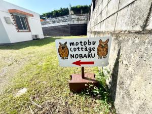 a sign with owls on it in a yard at 本部コテージnobaru in Motobu