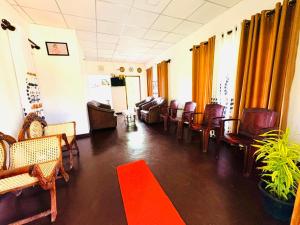 a waiting room with chairs and a red rug at Oli Guest House Diyathalawa in Diyatalawa
