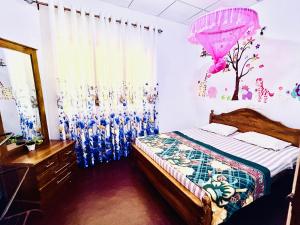 a bedroom with a bed and a pink umbrella at Oli Guest House Diyathalawa in Diyatalawa