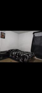 a bed with a black and white comforter at Bienvenidos Todos in Mexico City