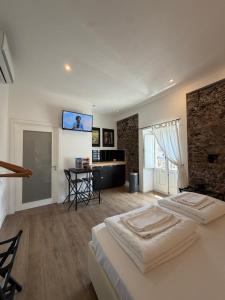 two beds in a room with a tv on the wall at Bibike in Catania