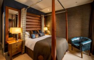 a bedroom with a bed and a blue chair at Heathmount Hotel in Inverness