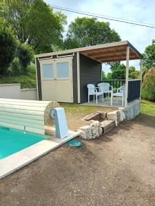 a small shed with a deck and a table at Gite de la Mouline in Lectoure