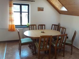 a dining room with a wooden table and chairs at Ubytování - Černá hora in Svoboda nad Úpou