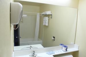 a bathroom with a sink and a large mirror at Budget Inn Anaheim near Disneyland Drive in Anaheim