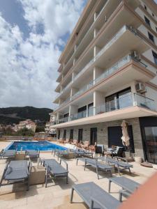 a hotel with a swimming pool and lounge chairs at Dreams house elia in Budva