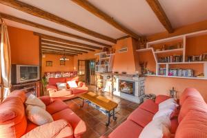 sala de estar con muebles de color naranja y chimenea en Los Montejos & Spa, en Valverde del Fresno