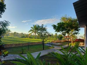 a view of a park with a mountain in the background at Nêst Guesthouse Tetebatu in Tetebatu