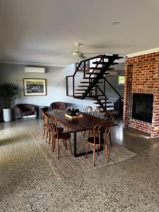 a dining room with a table and chairs and a fireplace at Lusso - Boutique Accommodation in Whitfield