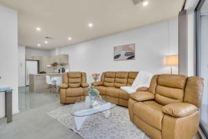 a living room with two couches and a table at Modern Metro by Host Solutions in Mawson Lakes