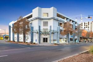 a white building on the side of a street at Modern Metro by Host Solutions in Mawson Lakes