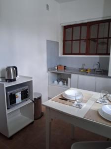 a kitchen with a table with plates and a microwave at Linas Apart & Suite in La Rioja +10 photos