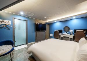 a room with a bed and a desk and a tv at G7 Hotel in Tongduch'ŏn