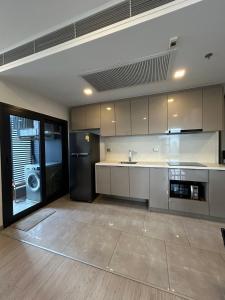 a large kitchen with a refrigerator and a sink at One9Five Asoke 可月租 in Ban Hui Yai Muk