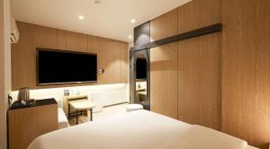 a hotel room with a bed and a flat screen tv at sotam stay hotel in Taeam