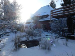 a garden covered in snow with a building in the background at Villa-Hufeland in Berlin
