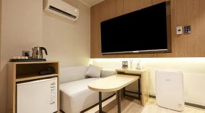 a room with a couch and a table and a tv at sotam stay hotel in Taeam