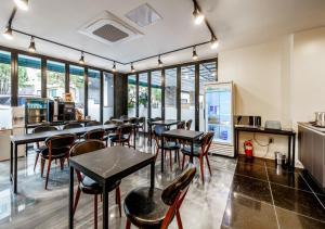 a restaurant with tables and chairs and windows at G7 Hotel in Tongduch'ŏn