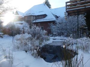 einen schneebedeckten Garten neben einem Haus in der Unterkunft Villa-Hufeland in Berlin
