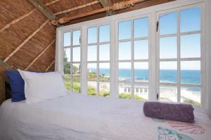 a bedroom with a bed with a view of the ocean at 61 Lutie Katz in Yzerfontein