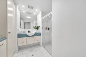 a white bathroom with a sink and a shower at Sub-Penthouse with Marina View by Host Solutions in Glenelg +38 photos