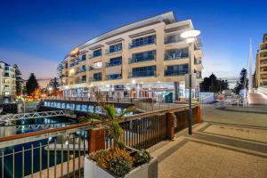 a building with a palm tree in front of it at Sub-Penthouse with Marina View by Host Solutions in Glenelg