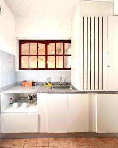 a kitchen with white cabinets and a counter top at Linas Apart & Suite in La Rioja