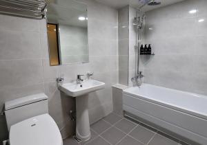 a bathroom with a toilet and a sink and a bath tub at Incheon Illuwa Hotel in Incheon